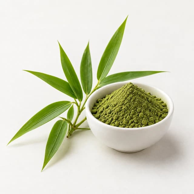 Slender bamboo leaves beside green leaf powder